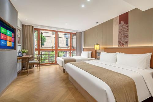 a hotel room with two beds and a television at Xi'an Xichen Hotel in Xi'an