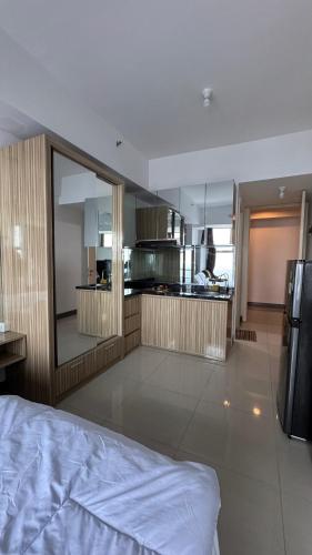 a large kitchen with a bed in a room at Apartemen Anderson pakuwon mall Luxury Studio Apartment Connecting Mall, Pool & City View 37B in Surabaya