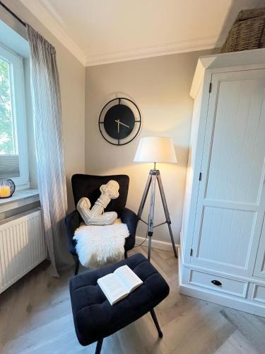 a living room with a chair and a stool at Ostsee Küstenliebe Grömitz in Grömitz