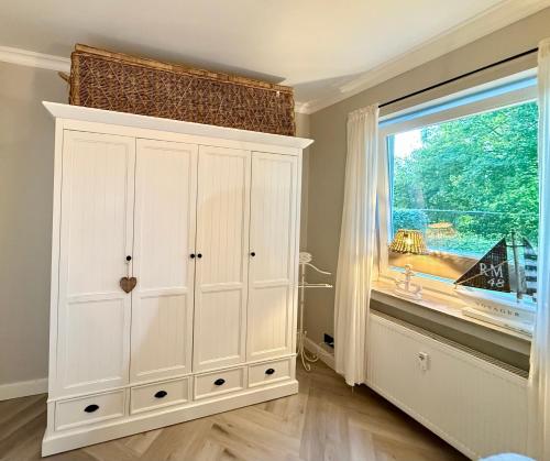 a white cabinet in a room with a window at Ostsee Küstenliebe Grömitz in Grömitz