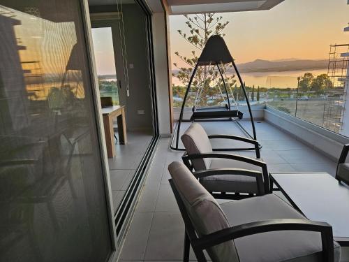 a balcony with chairs and a view of the ocean at Majestic Sunset Salt Lake Views 300m from beach in Larnaca