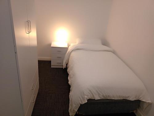 a small bedroom with a bed with a light on it at FlexiRoom on Abercrombie in Sydney