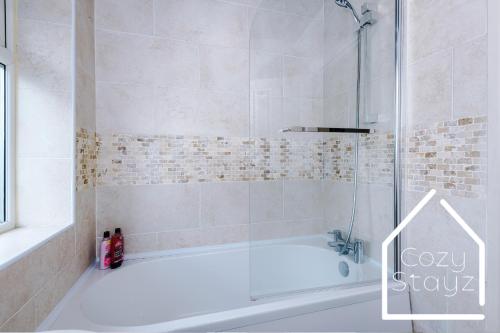 a bathroom with a shower and a bath tub at Spacious 3 Bed with Pac-Man, Darts and 2 Parking spaces in Manchester
