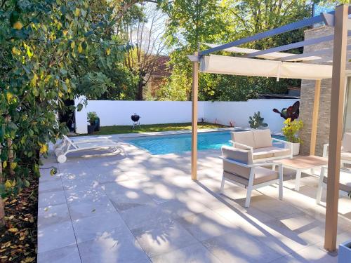 patio con sedia, ombrellone e piscina di Maison contemporaine a Floirac