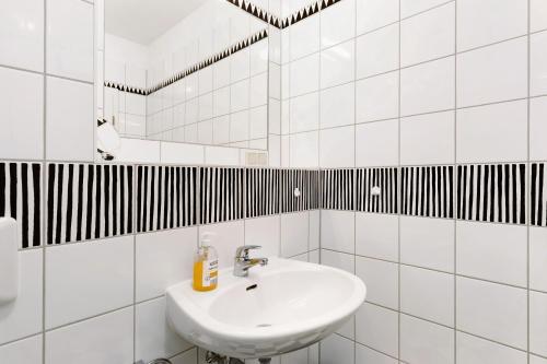 a white bathroom with a sink and a mirror at Studio-Apartment in Neu Fahrland