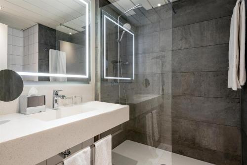 een badkamer met een wastafel en een douche bij NH Collection Berlin Mitte am Checkpoint Charlie in Berlijn