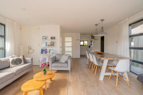 a living room and dining room with a table and chairs at Nautic Rentals - Watervilla's Zuiderhoeve in De Heen
