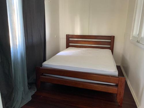 un petit lit dans une chambre avec une fenêtre dans l'établissement The Beach Cottage - close to beach and river mouth, à Guilderton