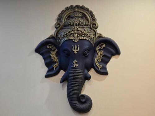 a wall mounted indian elephant head with a crown at Amoda - Best Hotel in Dharamshala in Dharamshala