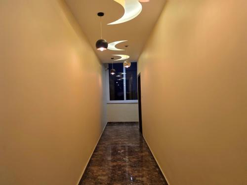 an empty hallway with a ceiling fan and a corridor at Amoda - Best Hotel in Dharamshala in Dharamshala