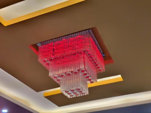a red chandelier is hanging from a ceiling at Amoda - Best Hotel in Dharamshala in Dharamshala