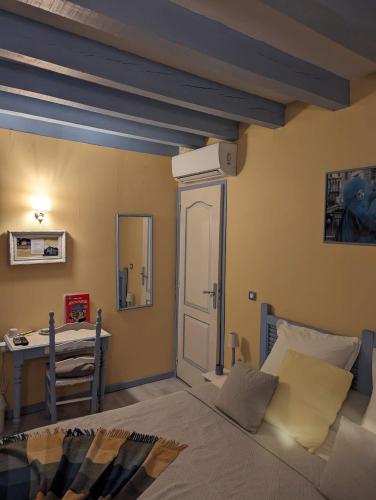 a bedroom with a bed and a desk in it at Les Hôtes Landes in Saint-Gor