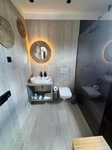 a bathroom with a sink and a toilet and a mirror at Curacao SPA in Lespezi