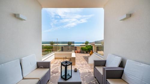 una sala de estar con sofás y vistas al océano. en Villa Petronilla sul mare, en Savelletri di Fasano
