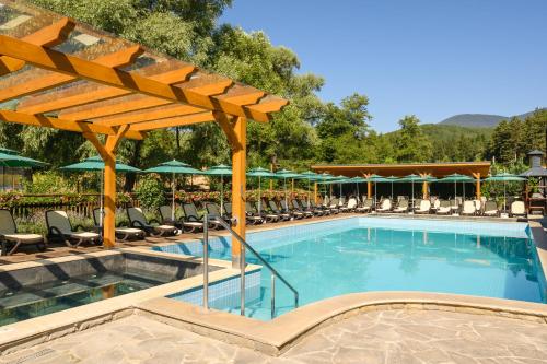 a pool at a resort with chairs and umbrellas at Thermal Camping Velingrad in Velingrad