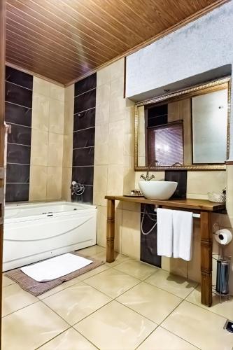 a bathroom with a tub and a sink and a mirror at Sakli Konak Cappadocia Hotel&Restaurant in Uçhisar