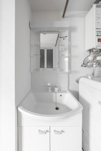 a white bathroom with a sink and a mirror at SERAPHIC 千歳MS101 in Chitose