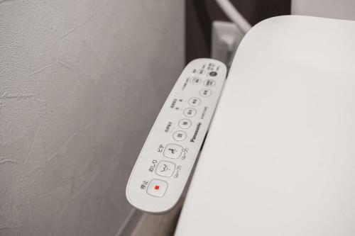 a white remote control sitting on top of a wall at SERAPHIC 千歳MS101 in Chitose