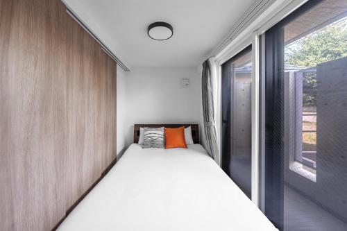 a bed in a small room with a window at SERAPHIC 千歳MS101 in Chitose