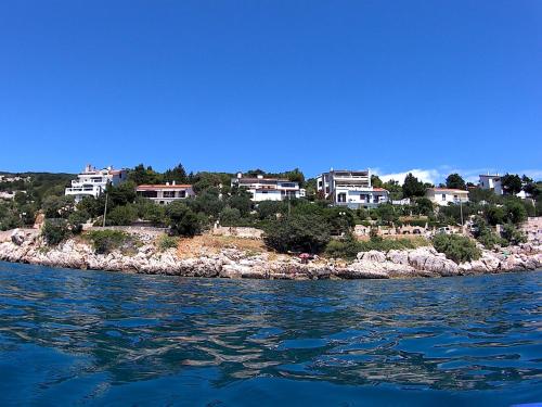 a group of houses on an island in the water at Apartments Peric in Baška