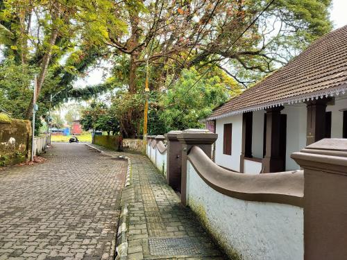 a fence next to a brick road next to a building at Honza Hostel in Cochin