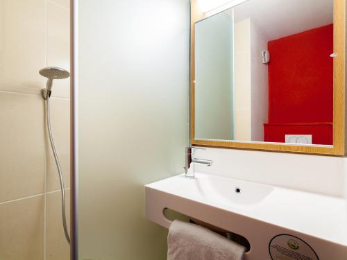 a bathroom with a white sink and a mirror at B&B HOTEL Montpellier Centre Le Millénaire in Montpellier