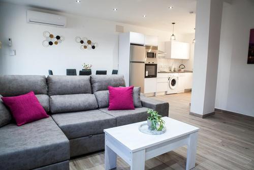 a living room with a grey couch and pink pillows at Casa Molino San Antonio in Córdoba