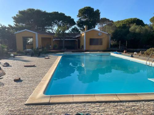 a swimming pool in front of a house at Casa Monti in Calasetta