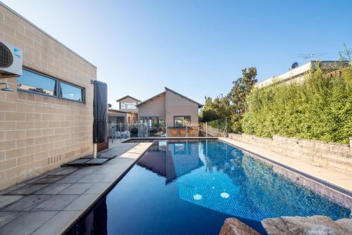 a swimming pool in front of a house at Rockleigh Bay - Gas Heated Spa and Solar Heated Pool in Mount Martha