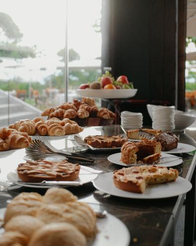 a table with various pastries and pies on plates at Relais & Spa Castello di Casiglio in Erba