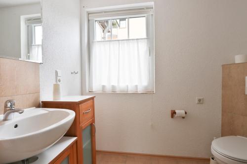 Bungalow Leuchtturm im Ostseeidyll am Waldrand في أوستسيباد نينهاجن: حمام مع حوض ومرحاض ونافذة