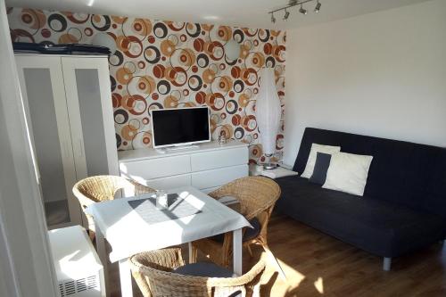 Bungalow Robbe im Ostseeidyll am Waldrand في أوستسيباد نينهاجن: غرفة معيشة بها أريكة وطاولة