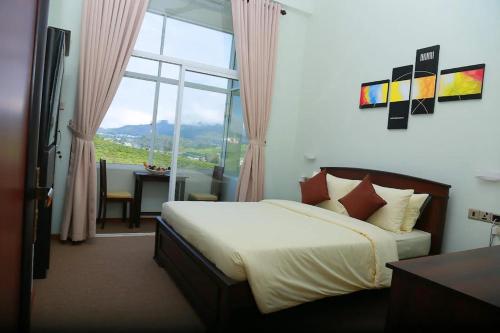 a bedroom with a bed and a large window at Oak Ray Misty Hills in Nuwara Eliya