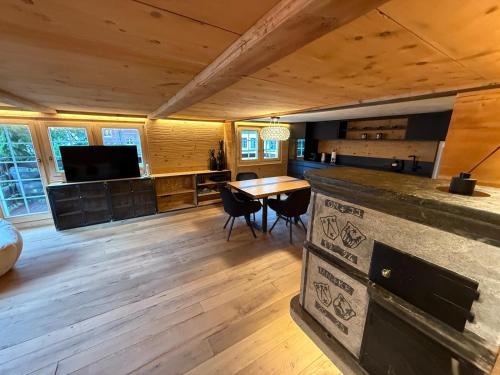 a large living room with a wooden floor and a table at TheNEST1895 in Zermatt