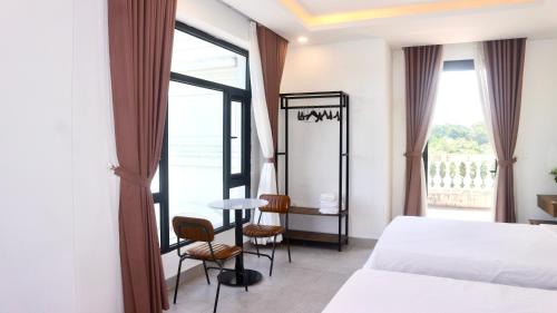 a hotel room with a bed and a window at Monstera Hotel and Coffee in Phú Quốc