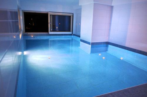 a swimming pool with a blue floor and a window at Apartments Rux de Luxe in Bar