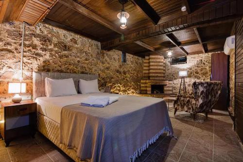 a bedroom with a bed and a stone wall at Casa Maria Hotel in Antalya