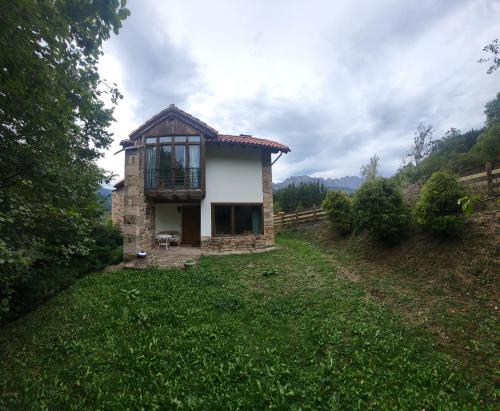a small house in the middle of a field at Explora Picos de Europa in Cosgaya