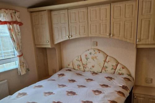 una camera da letto con un letto con copriletto floreale di Caravan - Sleeps 4 - Pet friendly - Parking a Newton Stewart