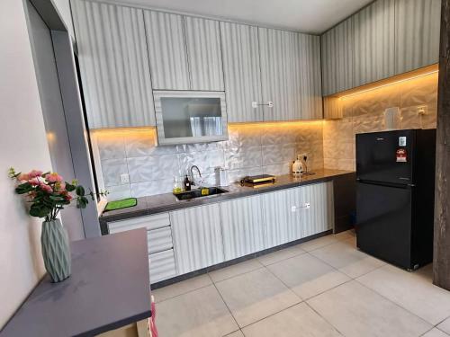 a kitchen with a black refrigerator and a sink at Urban Suites Georgetown Penang - Sea View & Georgetown View - High Floor - Exclusive & Cozy Stay in George Town