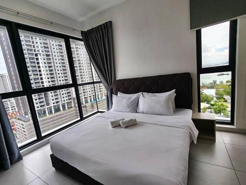 a bedroom with a large bed with large windows at Urban Suites Georgetown Penang - Sea View & Georgetown View - High Floor - Exclusive & Cozy Stay in George Town