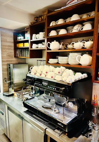 a kitchen with a counter with dishes on shelves at Zoe Bistro & Accommodation in Kilrush