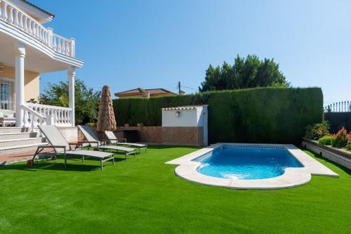 einen Hinterhof mit Pool und grünem Gras in der Unterkunft Panther Home Villa Valencina in Valencina de la Concepción