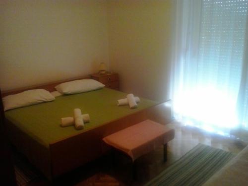 niewielka sypialnia z zielonym łóżkiem i 2 świecami w obiekcie Apartment Zeljka w mieście Bribir