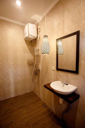 a bathroom with a sink and a mirror at Alpha Wolf Lodge in Cemagi