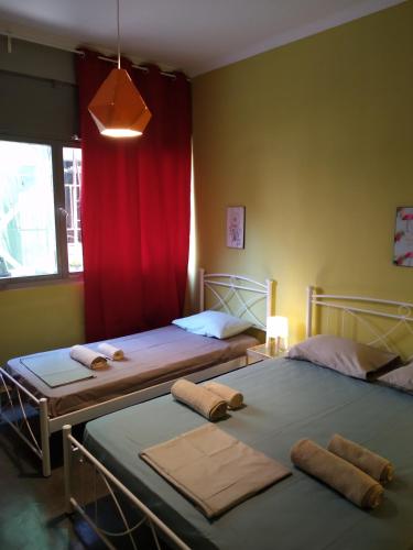 two beds in a room with a red curtain at Plaka Rooms in Athens