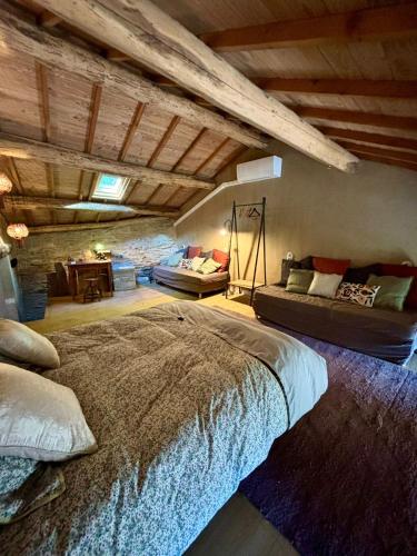 a bedroom with a large bed and a couch at Fount Estremiero - Chambres & tables d'hôtes in Castans