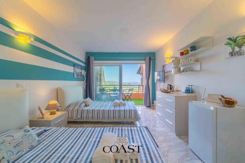 a bedroom with a room with a bed and a dresser at Blue Skyline | Sea View Terrace in Portisco in Olbia