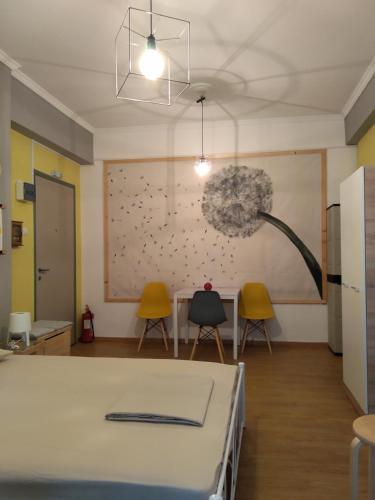 a room with a table and two chairs and a painting at Plaka Rooms in Athens