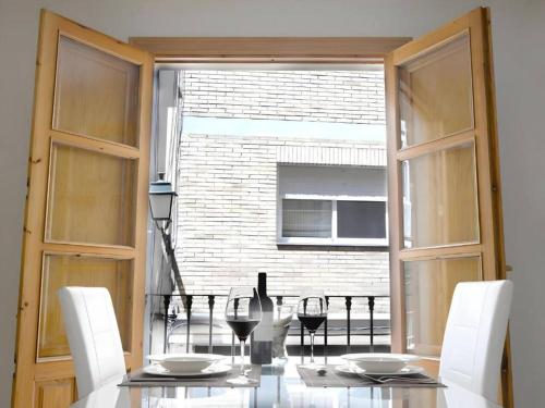 a dining room with a table and chairs and a window at Apartamentos Silleria - A 4 min de la Catedral de Granada in Granada